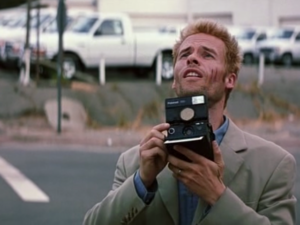 An image of Guy Pearce holding a camera in Memento (2000). Caption: Have you seen John G? I need to ask him about the history of the Aiel.